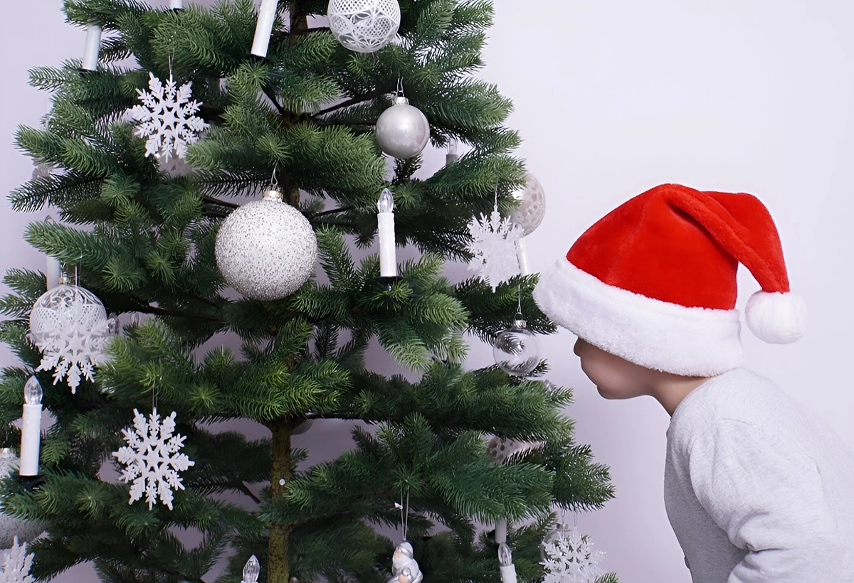 Weihnachtsbaum weiß geschmückt mit Kugeln, Sternen und Kerzen