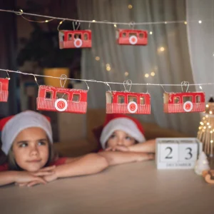 zwei kleine kinder mit einem selbstgemachten adventskalender in form eines zuges