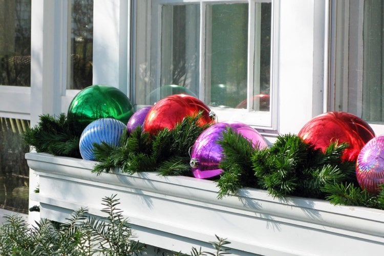 Fensterbank aussen weihnachtlich dekorieren Ideen mit großen Kugeln