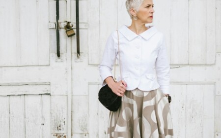 Fashionable Senior Woman Standing In Front Of The White Door