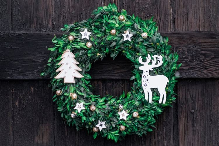 Weihnachtlich dekorieren Türkranz aus Naturmaterialien wie Eukalyptus und mit selbstgemachtem Weihnachtsbaumschmuck aus Papier