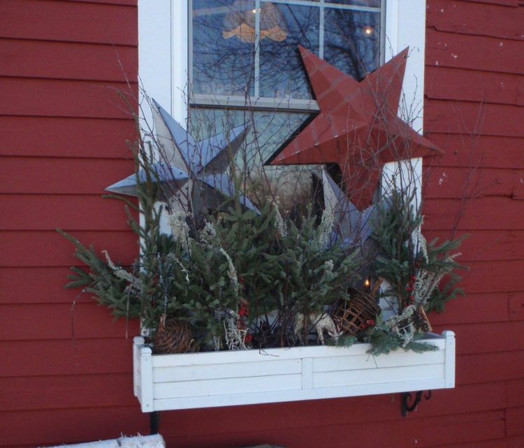 Weihnachtsdeko Fensterbank aussen Sterne aus Metall und Dekobälle und Tannenzweige arrangieren