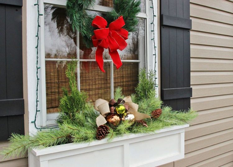 grüne und bronze Weihnachtskugeln und Zypressenzweigen und Kieferzweige und Türkranz aus Tannengrün als weihnachtliche Fensterdeko