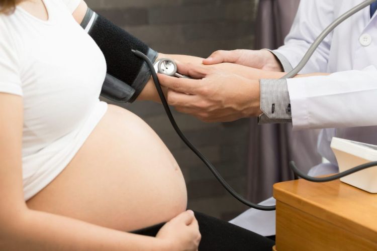 arzt untersucht schwangere frau für bluthochdruck
