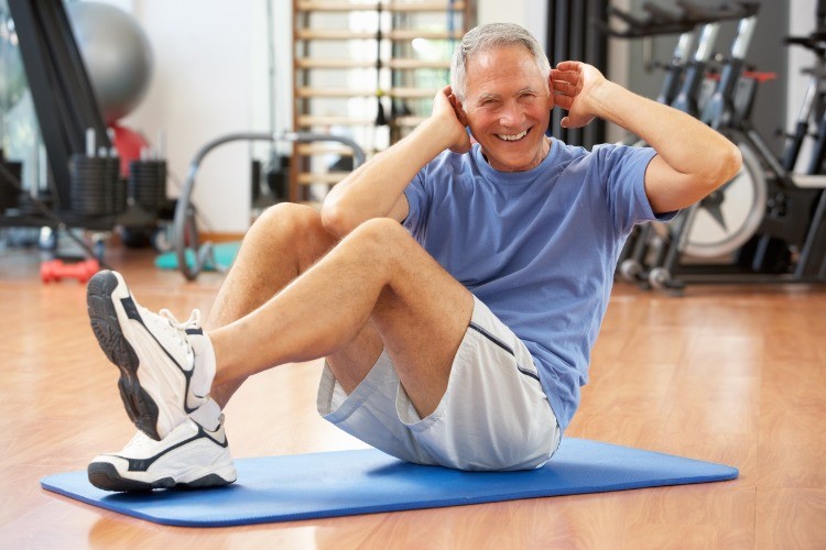 älterer mann macht seitliche bauchpressen und fitnesstraining für senioren