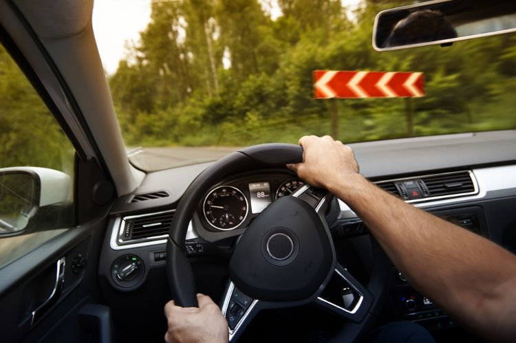 lenken mit den händen in richtiger position am steuer an der kurve im auto