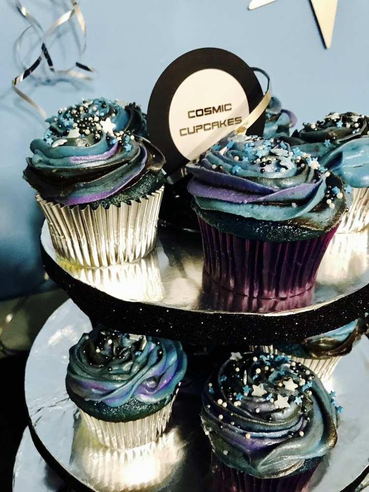 Attraktive Cupcakes mit kosmischer Optik auf einem Dessertständer