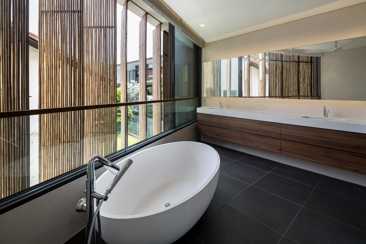 Badezimmer mit Fenster und modernen Badbmöbeln und Keramik Badewanne