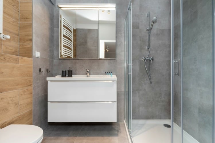Bodenebene Dusche mit Duschwanne und minimalistischer Waschschrank im kleinen Badezimmer