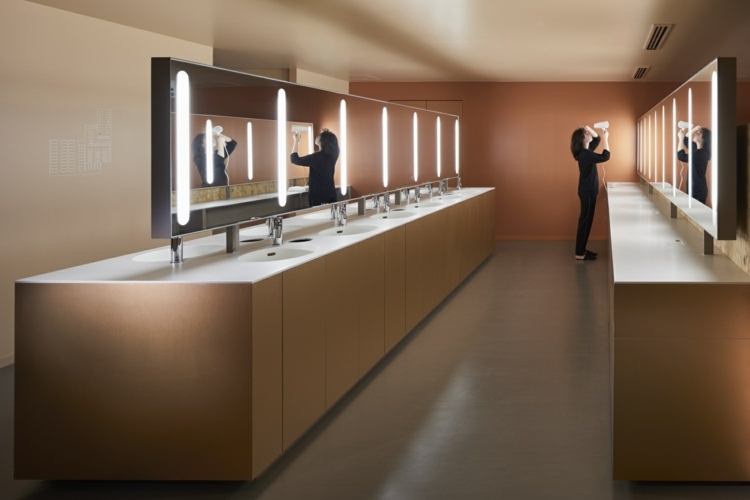 Gemeinschaftliche Sanitärlounge im Kapselhotel in Japan mit Spiegeln und Waschbecken