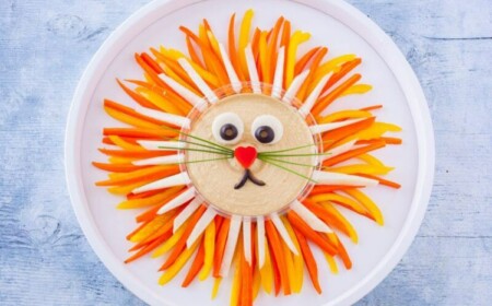Gemüseplatte mit Dip aus Hummus arrangiert mit Gemüse wie ein Löwe