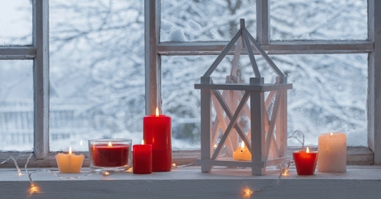 Laternen und Kerzen auf dem Fensterbrett verteilen für romantische Winterabende