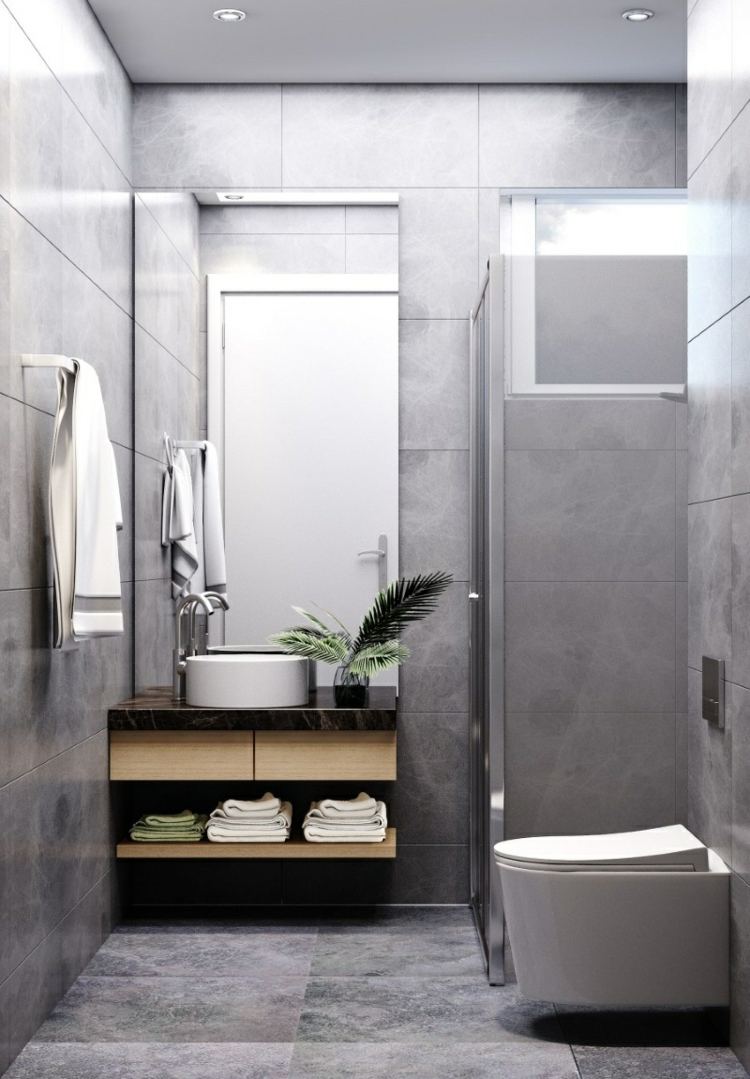 Minimalistisch und monochrom in Grau mit praktischer Aufteilung von Dusche, Toilette und Waschbecken