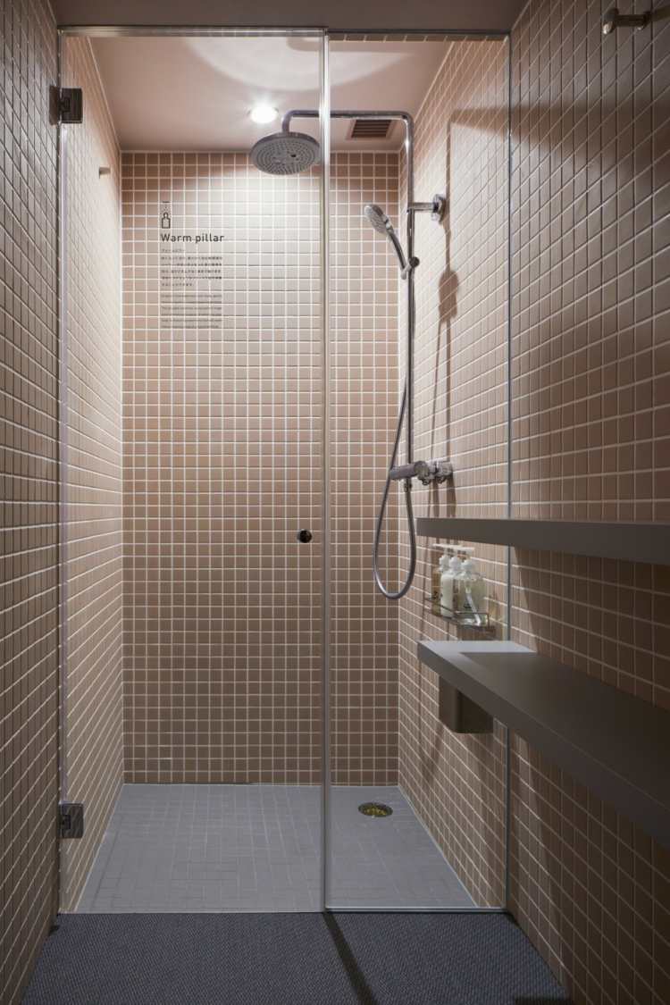 Moderne Dusche mit Regenduschkopf und Mosaikfliesen in Beige