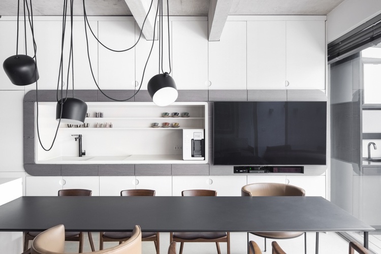 Moderne minimalistische Küche mit weißen Schrankfronten und schwarzen Esstisch mit Pendelleuchte