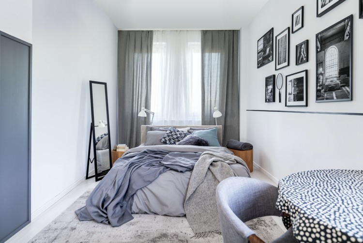 Schlafzimmer in grau mit Gallerie-Wand in Schwarz-weiß
