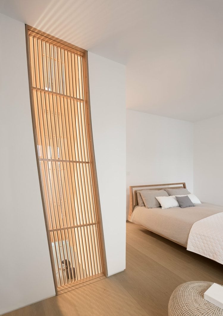 Schlafzimmer in natürlichen Farben und Sichtschutz am Fenster aus Holz