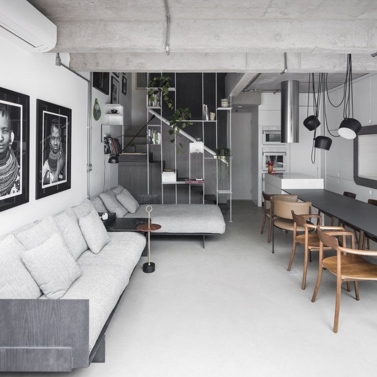Wohnzimmer in Schwarz Weiß und Grau einrichten modulares Sofa und weiße Wände und schwarzweiße Bilder als Wanddeko