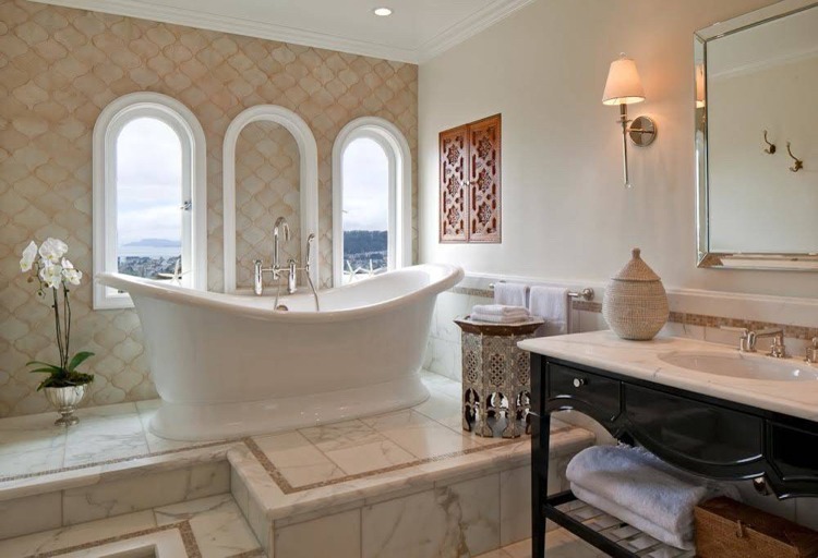 Ceramic bathtub and natural stone floor and wall tiles in the Spanish bathroom