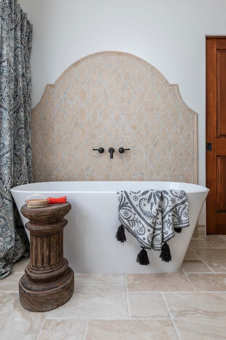 Badezimmer im modernen spanischen Stil mit Naturstein am Boden und freistehender Badewanne