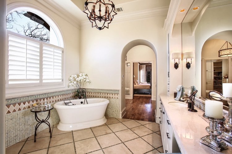Spanish-style bathroom with mosaic tiles on the wall and floor and chandeliers with LED candles