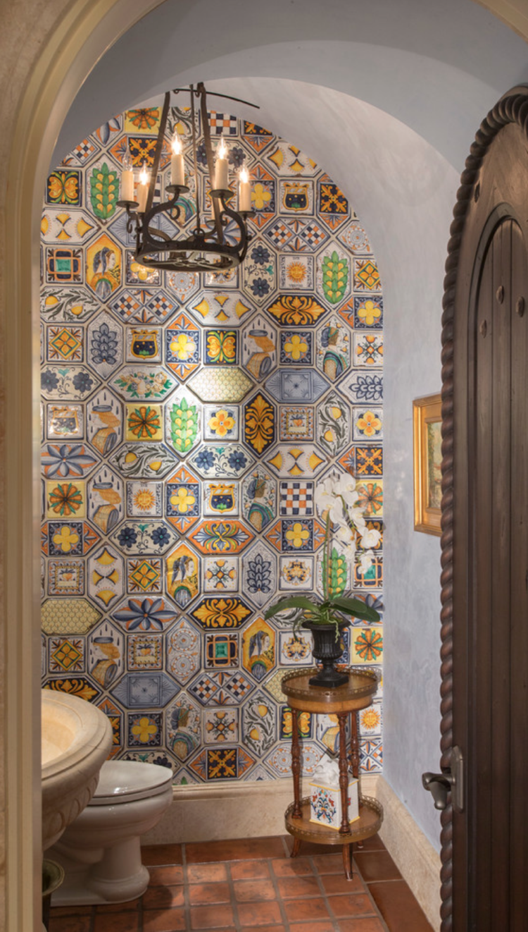 Bathroom with patchwork tiles on the wall and teraccotta on the floor
