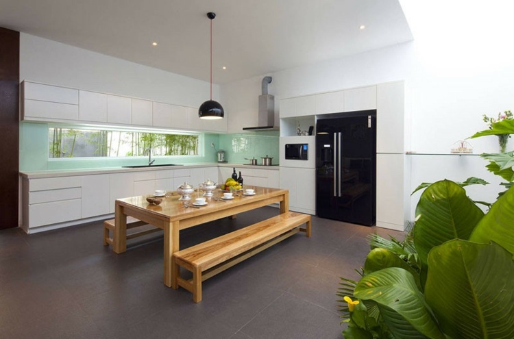 Offene Küche mit pastellgrüner Rückwand und minimalistischem Schrankdesign