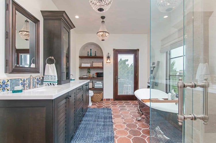 Spanish bathroom with teraccotta tiles on the floor and dark solid wood bathroom cabinets and white vanity