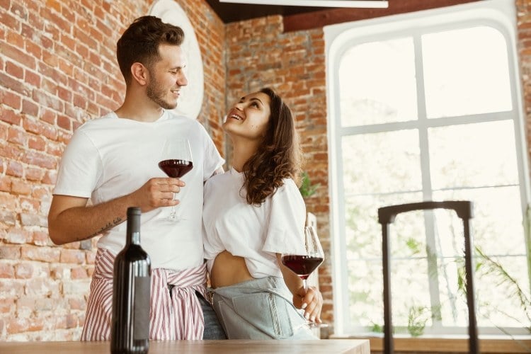 Tipps für Frühjahrsputz junges Paar trinkt Wein nach dem Ausmisten