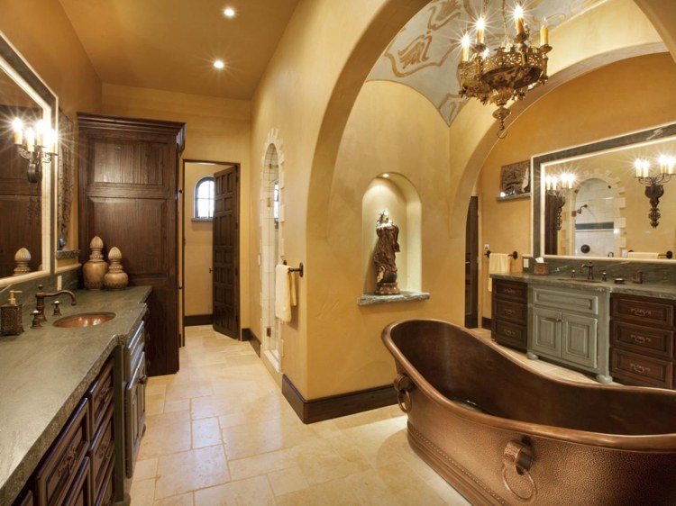 spanish bathroom with copper tub and walls without tiles and colonial style wooden cabinets and chandelier
