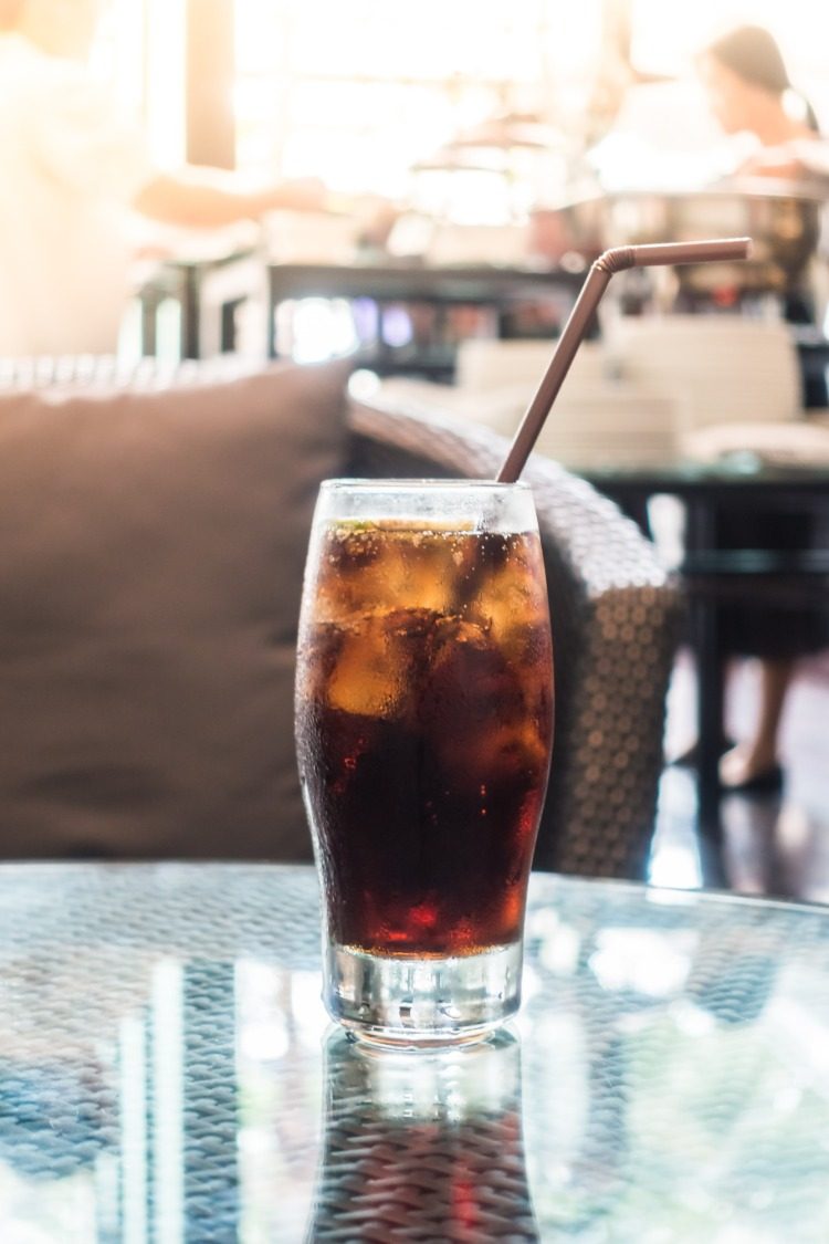 eiswürfel kühlen ein glas mit cola im cafe