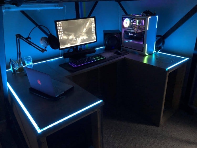 leuchtende led streifen entrlang gaming schreibtisch im dunklen spielzimmer