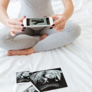 schwangere frau macht foto vom baby ultraschall