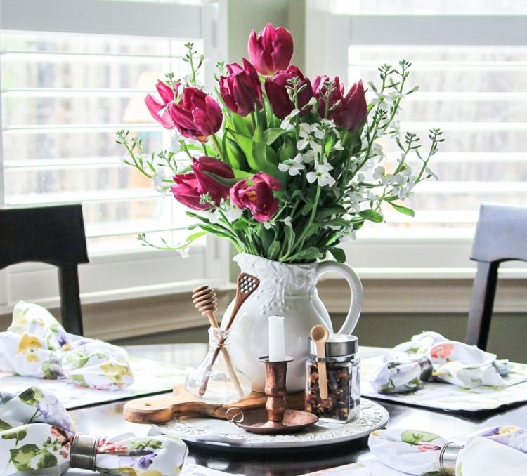 Blumenstrauß aus Tulpen in einer weißen Kanne als Tischdeko