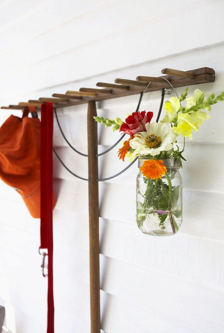Gartendeko an der Hauswand mit Marmeladenglas als Vase