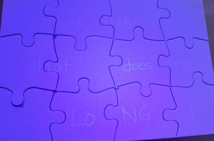 Puzzle mit Rätselfrage, die mit UV-Stift aufgeschrieben wurde