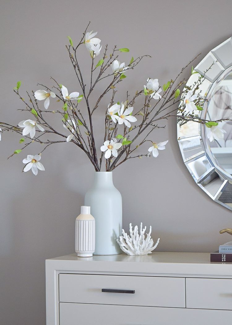 Schöner Strauß aus weiß blühenden Zweigen auf einem modernen Sideboard