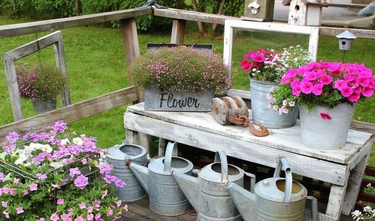 Teekannen und Blumen auf der Terrasse arrangieren