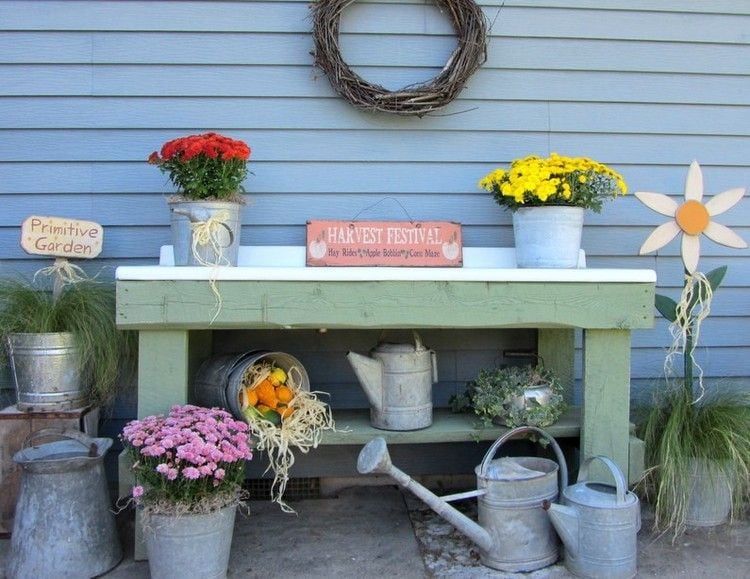 Vintage garden table decorate with flowers in buckets