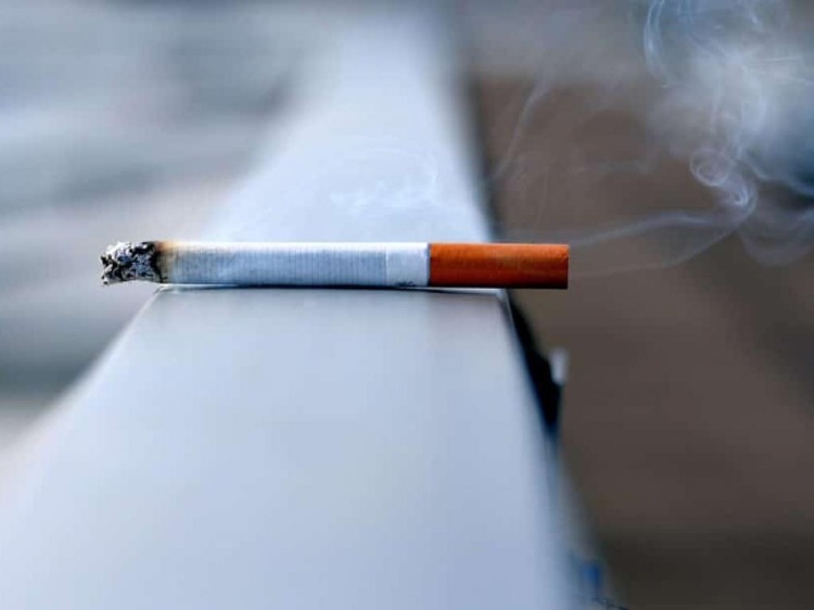 brennende zigarette auf einem geländer gelassen rauchen coronavirus pandemie