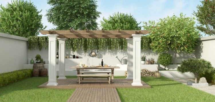 Comfortably designed garden with picnic table under pergola surrounded by lawn and plants