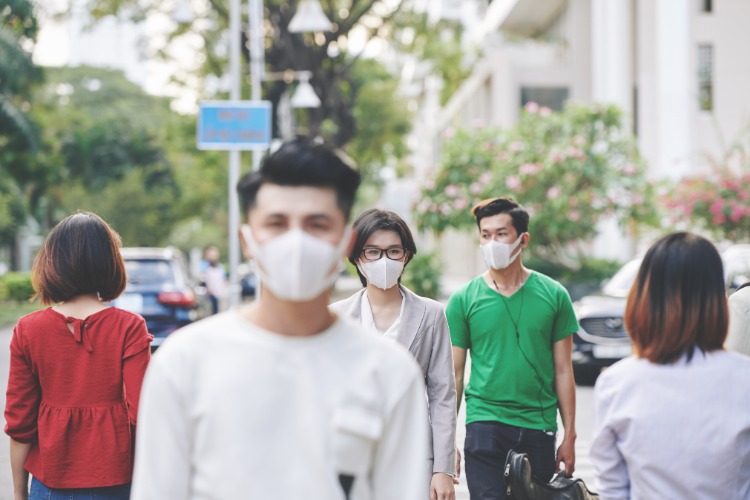 mehrere einwohner in china wuhan stadt mit schutzmasken auf den straßen spazierend