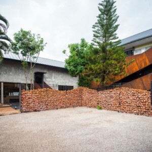 nachhaltiges hotel mit zaun aus recycelten ziegeln und betonmauern