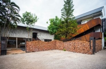 nachhaltiges hotel mit zaun aus recycelten ziegeln und betonmauern
