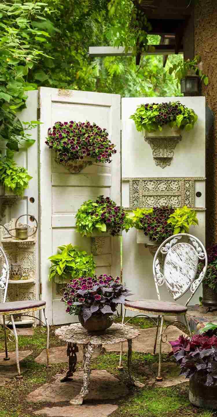 Privacy screen from old doors with hanging flower pots in retro style