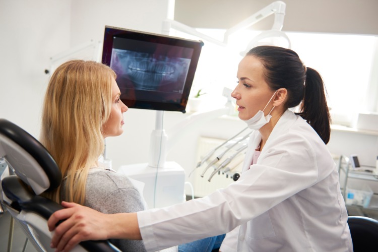 zahnärztin beruhigt patientin während ärztliche untersuchung zahnarztangst vorbeugen