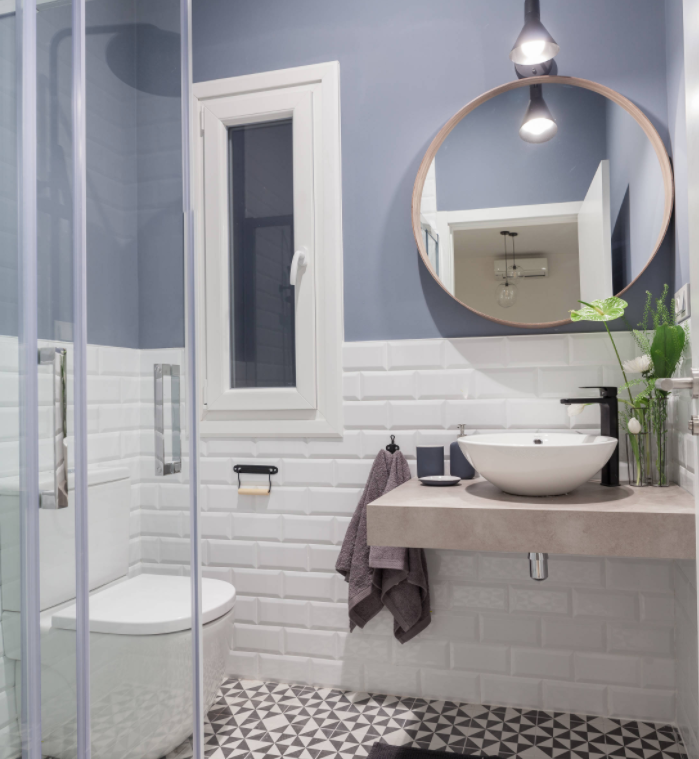 Badezimmer mit Metrofliesen in Weiß halbhoch verlegt und graublaue Wandfarbe