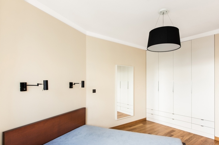Helles Schlafzimmer mit Wandfarbe Pfirsich und weißer, eingebauter Kleiderschrank