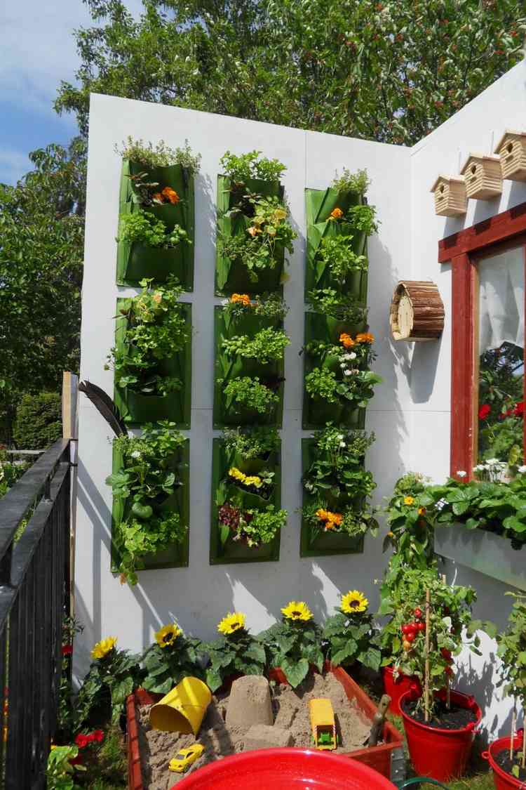 Mit Pflanztaschen und Blumen eine Balkonwand dekorieren