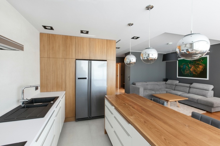Weiße Küchenschränke und Holzoberflächen, kombiniert mit eingebautem Kühlschrank in Silber